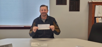 Mayor Tyler Nelson holding check